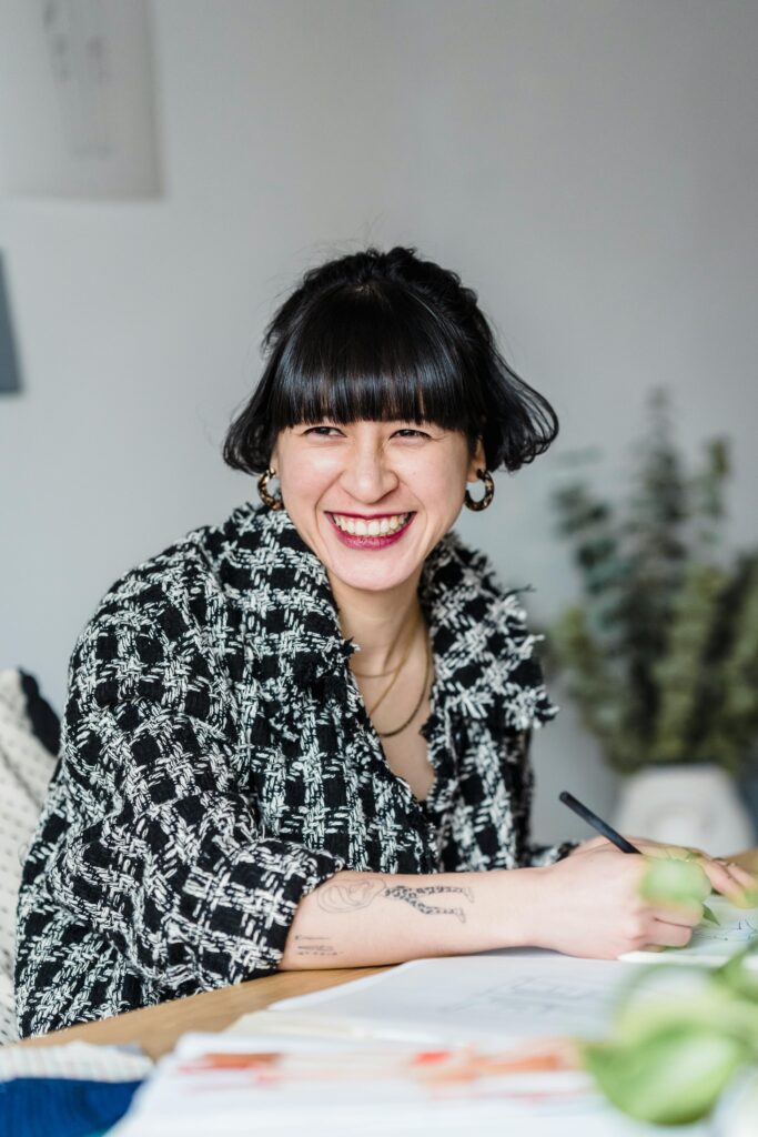 Women with a smile sitting at a table drawing, letting go of control and stepping into courage.