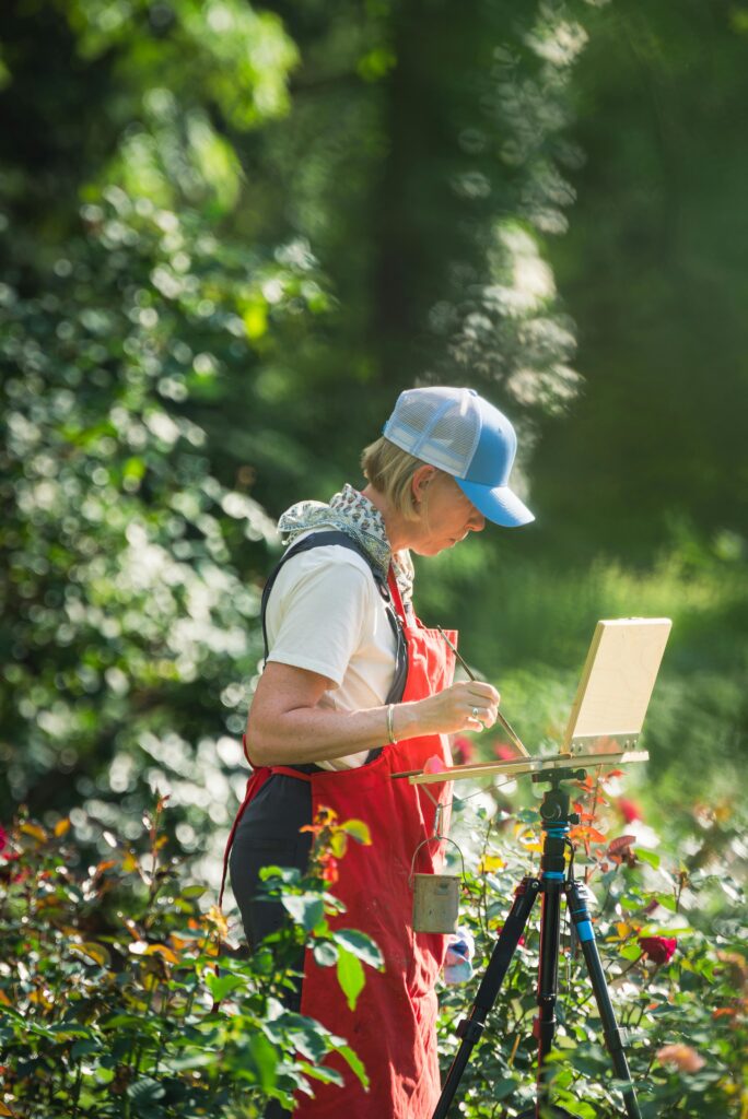 Woman painting in the garden embracing midlife.